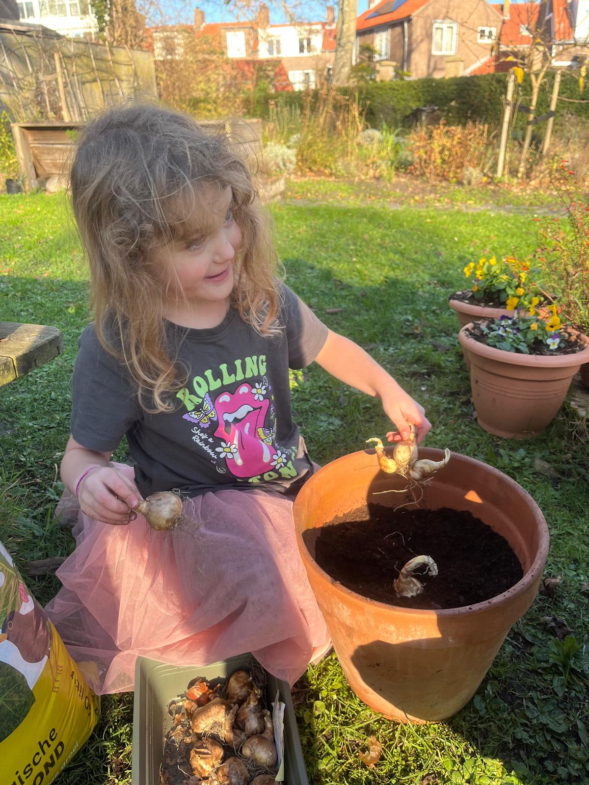 Kind plant bloembollen tijdens een tuinmoment